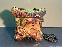 Front view showing geisha decoupage panel, red swirl bead border and metal coin charms at base