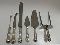 All six utensils laid flat showing full set.