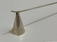 Close-up of cone-shaped snuffer head showing hinge mechanism and Tiffany hallmark