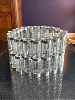 Assembled circular configuration of 21 clear glass tubes with metal rings