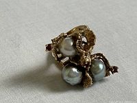 Top-down view of ring showing three remaining pearls and ruby accents in cluster design