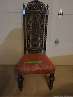 Front view showing carved backrest and upholstered seat.