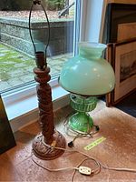 Both lamps side by side: green glass lamp with shade on right and carved wood lamp base on left