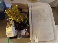 Overview photo showing all items including two tinsel garlands, a box of ornaments and potpourri, Easter eggs, and beads.