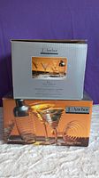 Two boxed sets of martini glasses and shakers by Anchor Hocking, packaging visible with product images and branding.