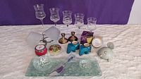 Overall lot showing all glassware, candle holders, pottery bird, tins, and appetizer set