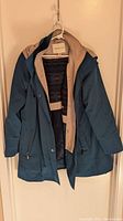 Blue Coldwater Creek raincoat with beige lining partially open showing interior and sweater inside