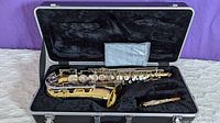 Open view of Yamaha alto saxophone body in black hard case with separate neck and missing mouthpiece
