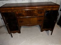 Photo showing Art Deco French wooden desk with two glass door cabinets flanking central drawers, good condition.
