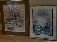 Two framed pictures, one landscape creek scene with trees, another featuring white birds amidst flowers, both with decorative frames.