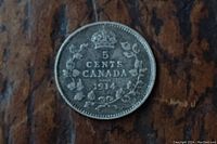 Close-up of the reverse side of the 1914 Canadian 5 cent coin showing crown above the numeral 5 with the inscription 'CENTS CANADA 1914' and wreath detail.