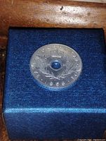 Top side of the 1959 Israeli 20 Agorot coin, showing Hebrew text, a crown emblem, and a hole in the center.