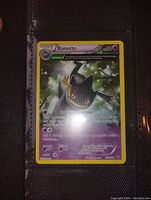 Close-up photo of Banette full art Pokemon card showing card artwork, text, and stats.