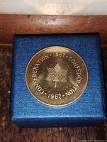 Front side of the 1967 Canada Confederation medallion showing 'CONFEDERATION 1867-1967' text around a geometric emblem.