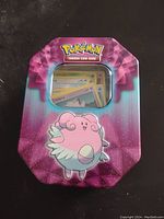 Closed collectible Pokemon tin with Blissey design visible on front and Pokemon Trading Card Game logo