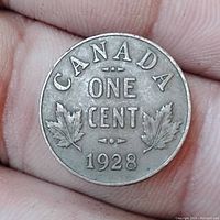 Reverse side of 1928 Canada One Cent coin showing denomination, year, and maple leaves.