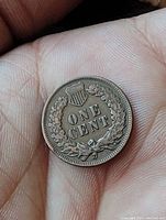 Close-up of reverse side showing wreath, shield, and 'ONE CENT' denomination.