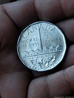 Reverse side of the 1951 Canadian nickel coin displaying mining buildings, maple leaves, and text related to Sudbury Mine and The Big Nickel.