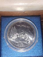 Image of the 1983 British Columbia Jasper Timber Wolf coin encapsulated in a protective plastic case, showing the detailed design of two timber wolves with a mountain and tree background, minted in 1983.