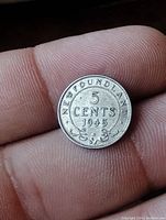 Close-up of reverse side of 1945 Newfoundland silver coin showing denomination and date.