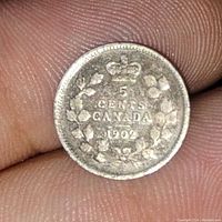 Close-up photo of the 1902 Canadian 5 cent coin showing the crowned wreath and denomination details with tonal patina.