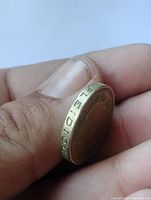 Side view of coin showing detailed edge pattern