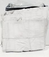 Folded grey sheet set packaged inside zippered pouch, showing fabric pattern and packaging.