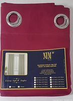 Close-up photo of the curtain label with product details, showing the burgundy colored curtain panel with silver grommets. Label states Blackout Eyelet Tab Top, 3 layers thermal fabric, noise reduction, heat and sun blocking, and approximate measurements for different sizes including 55" x 84".