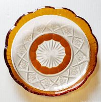 Top view of the clear hand cut crystal plate showing intricate star and geometric patterns with deep amber scalloped edge.