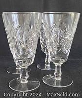 Four clear hand cut crystal goblets with squared stems shown standing grouped together showcasing intricate pinwheel/Star of David hand cut patterns on the bowls.