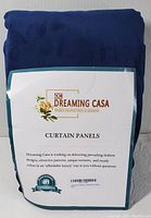 Packaged blue curtain panels by Dreaming Casa showing brand label and product name