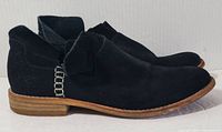 Side profile view of the black suede Clarks Artisan booties showing wooden stacked heel and loop detail.