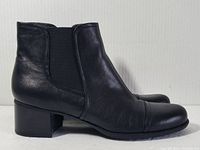 Side view of black leather bootie showing elastic panel and block heel.