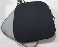 Two black chair pads stacked, showing top and non-slip bottom surface