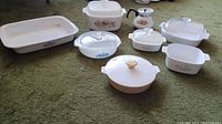 Full lot of CorningWare pieces including various patterns and shapes, showing condition and layout