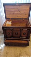 Front view of open cedar chest showing interior wood lining and original cedar shavings box.