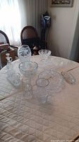 Wide shot of the crystal glassware lot laid out on a table, showing various shapes and sizes