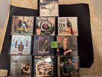 Ten CDs arranged in a group showing a variety of album covers including Dixie Chicks, Ace of Base, and Travis Tritt