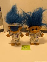 Front view of two Blue Jay Troll dolls with blue hair and baseball uniforms, showing jersey numbers 47 and 12.