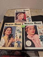 Set of three Woman and Home magazines arranged on surface showing covers