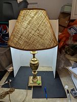 Full view of the brass lamp with fabric shade showing overall condition and design.