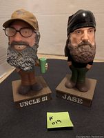 Front view of Uncle Si and Jase Duck Dynasty bobbleheads on square wooden bases with names.