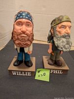 Front view of Willie and Phil Duck Dynasty bobbleheads on bases with names