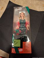 Front view of the Holiday Surprise Barbie doll in original box showing the doll with holiday green dress and box graphics.