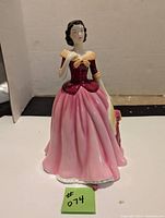 Front side view of Royal Doulton figurine Mary standing with pink skirt and maroon top