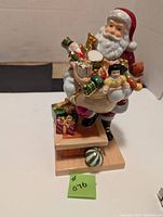 Front view of Royal Doulton Rooftop Santa holding a sack of toys on rooftop base showing details of toys and presents.