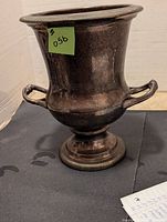 Front and side view of silver plate ice bucket showing its urn shape, two handles, flared rim, and tarnished surface.