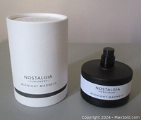 Nostalgia Perfumery Midnight Madness perfume bottle without cap next to its original white textured box, showing front labels clearly.