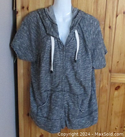 Full front view of grey marled short sleeved hoodie on mannequin showing zip front and two front pockets.