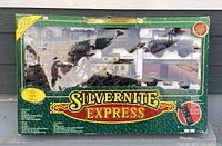 Front of the original box showing Silvernite Express Christmas train set including locomotive, tender, and freight cars in clear packaging insert.